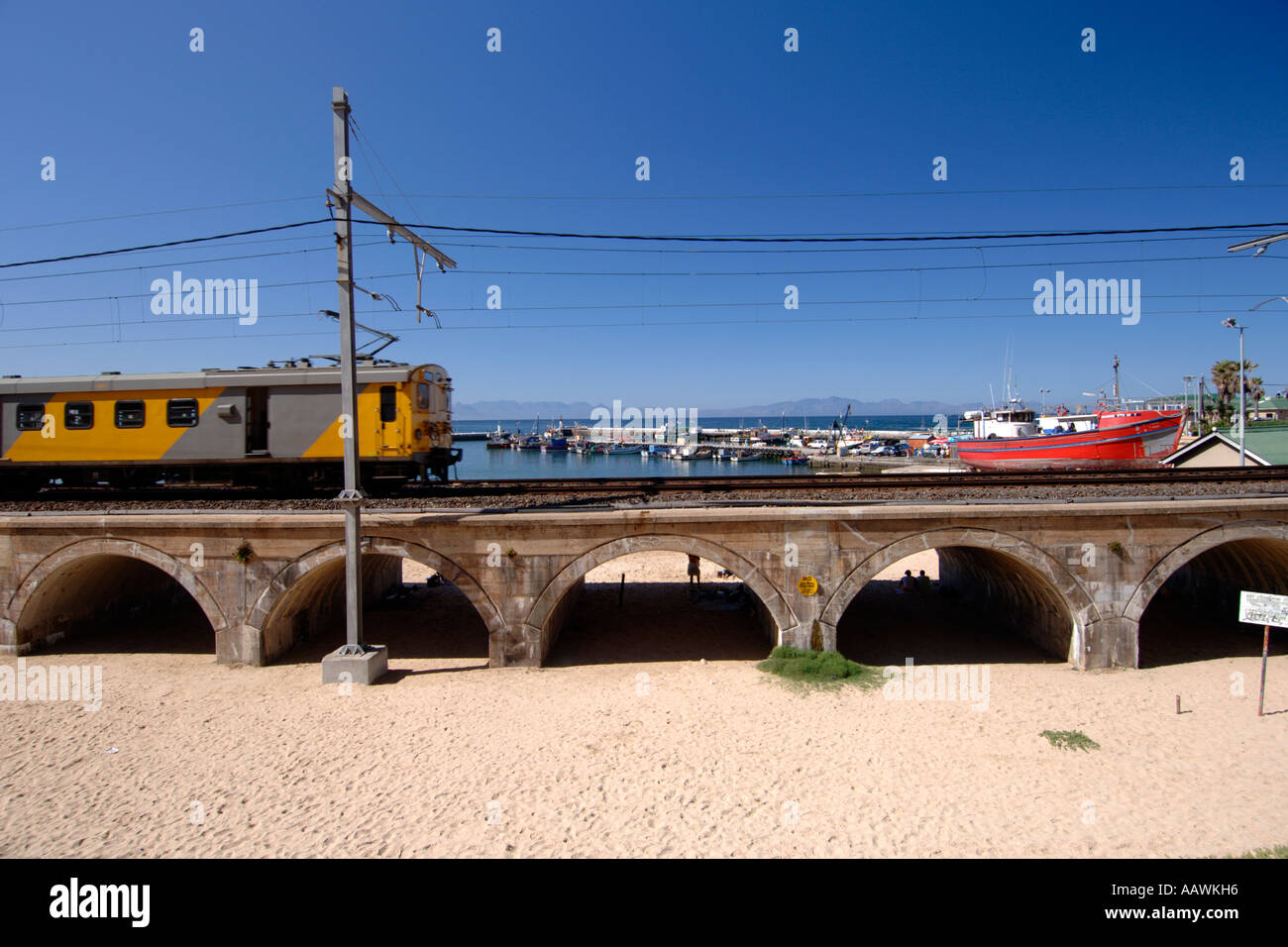 Un train en direction de passé sur le port de Kalk Bay Cape Town's littoral de l'océan Indien en Afrique du Sud. Banque D'Images