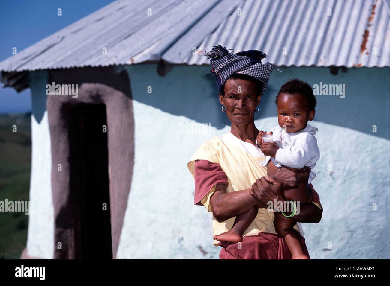 Une femme Xhosa avec sa fille dans ses bras à l'extérieur de sa hutte en Afrique du Sud, Province du Cap oriental. Banque D'Images