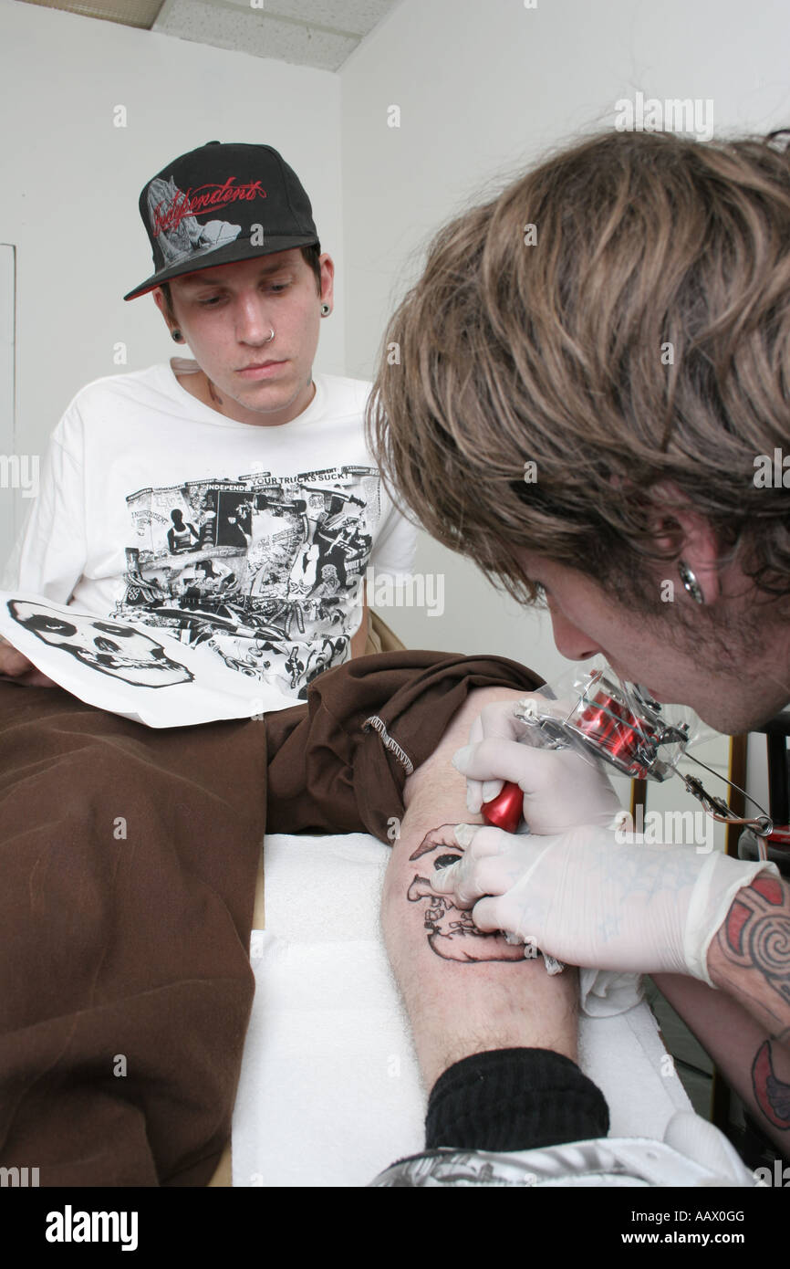 Un tatouage d'un crâne humain sur la jambe d'un homme. Banque D'Images