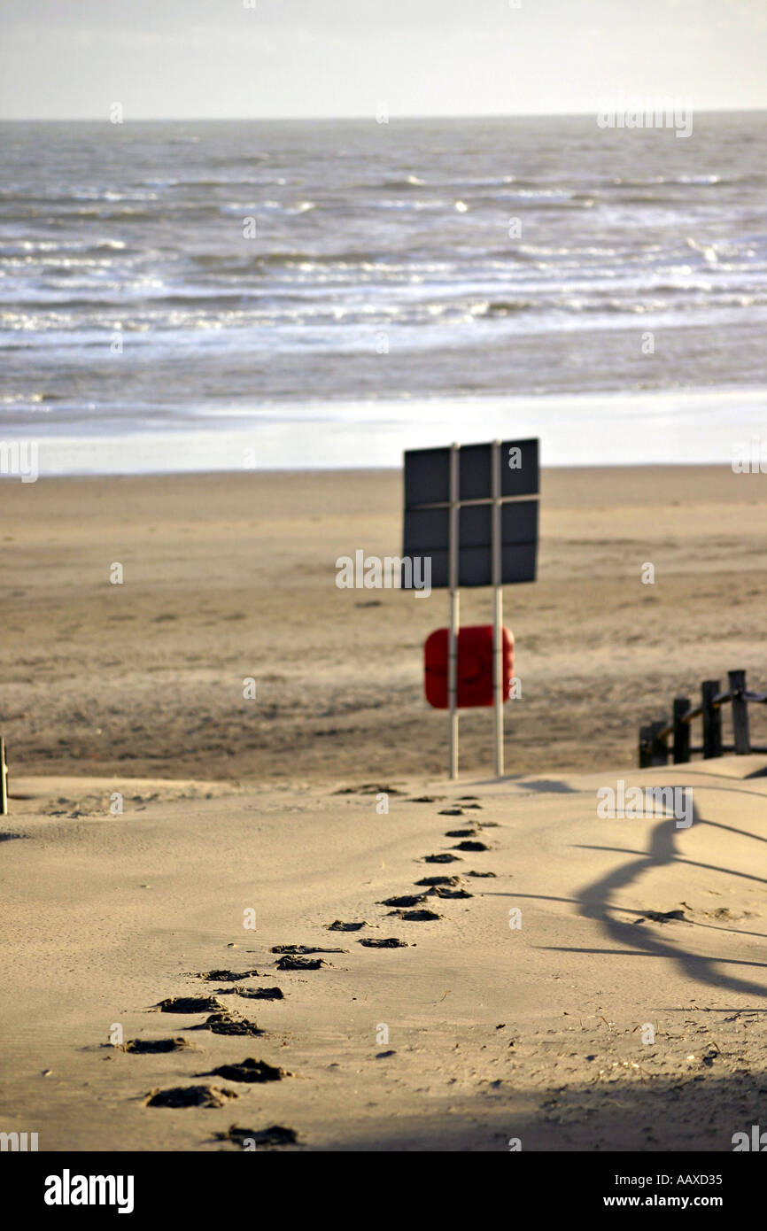 Plage de sable empreintes avertissement bouée ceinture vie côte anneau Banque D'Images