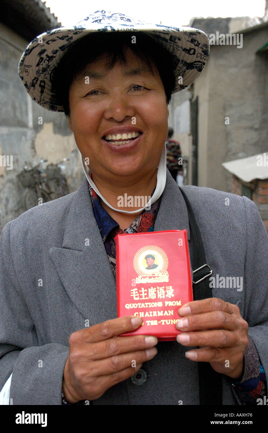 Femme vendant le président Mao s petits livres rouges aux touristes dans un hutong de Beijing China 2005 Banque D'Images