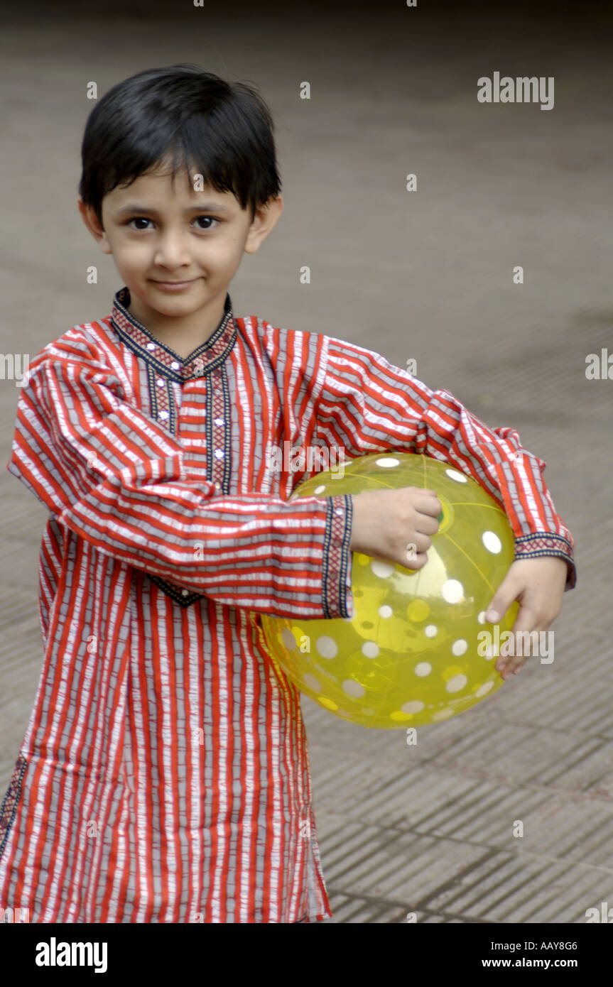 Enfant indien à Kurta holding ball pvc plastique modèle publié dans sa main Banque D'Images
