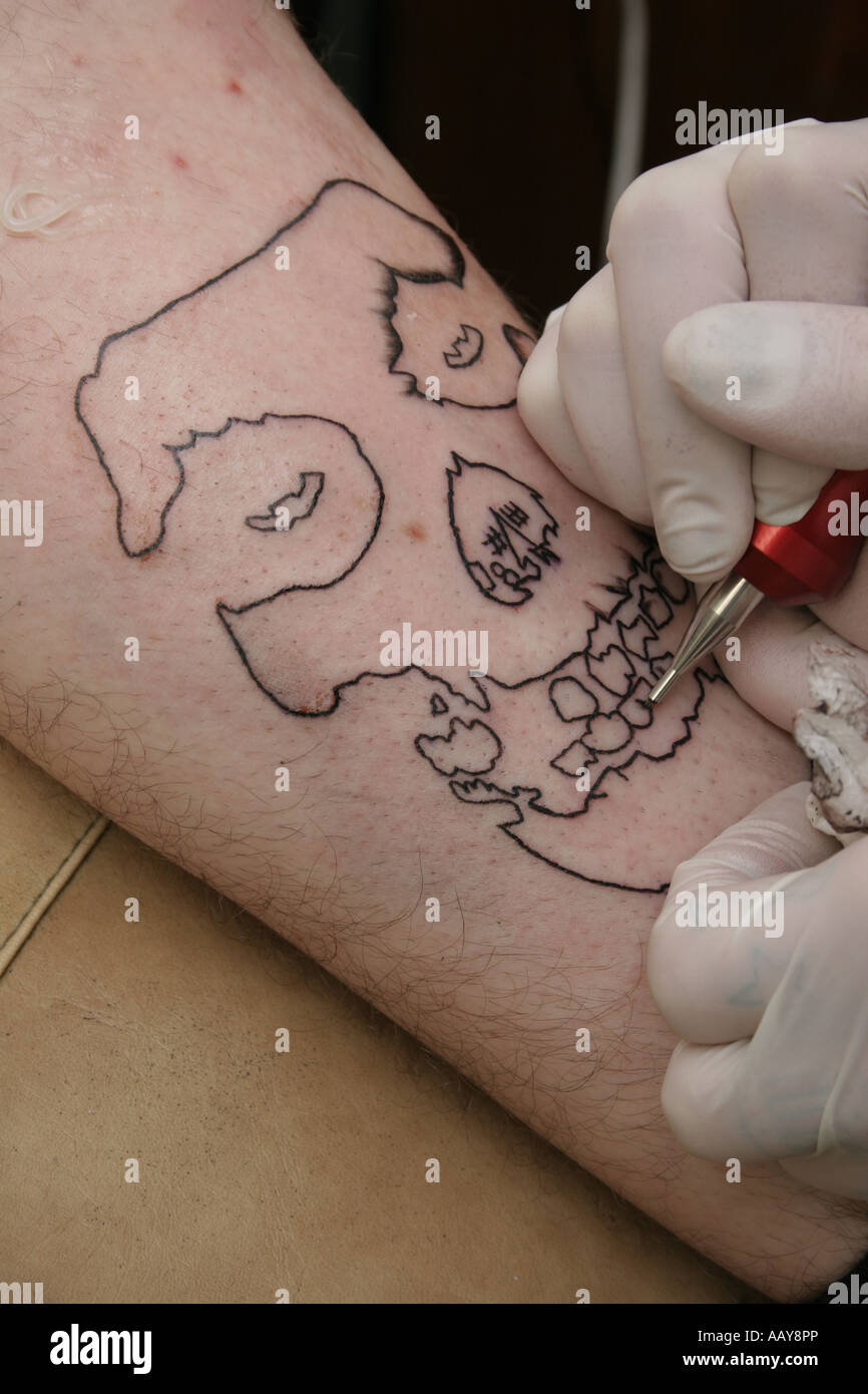 Un tatouage d'un crâne humain sur la jambe d'un homme. Banque D'Images