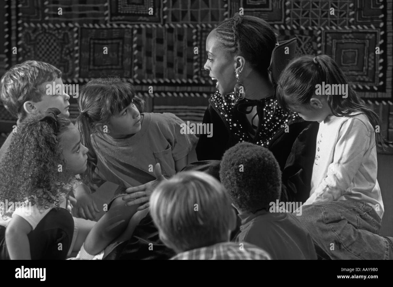 Photo en noir et blanc d'un conteur africain-américain des femmes de diverses origines ethniques avec groupe d'enfants Banque D'Images Photo en noir et blanc d'un conteur africain-américain des femmes de diverses origines ethniques avec groupe d'enfants Banque D'Images
