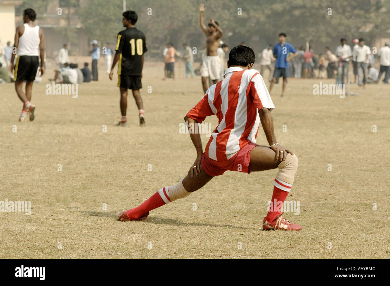 Garçon exerçant avant de jouer au football dans le terrain de jeu Bombay Maharashtra Inde Banque D'Images