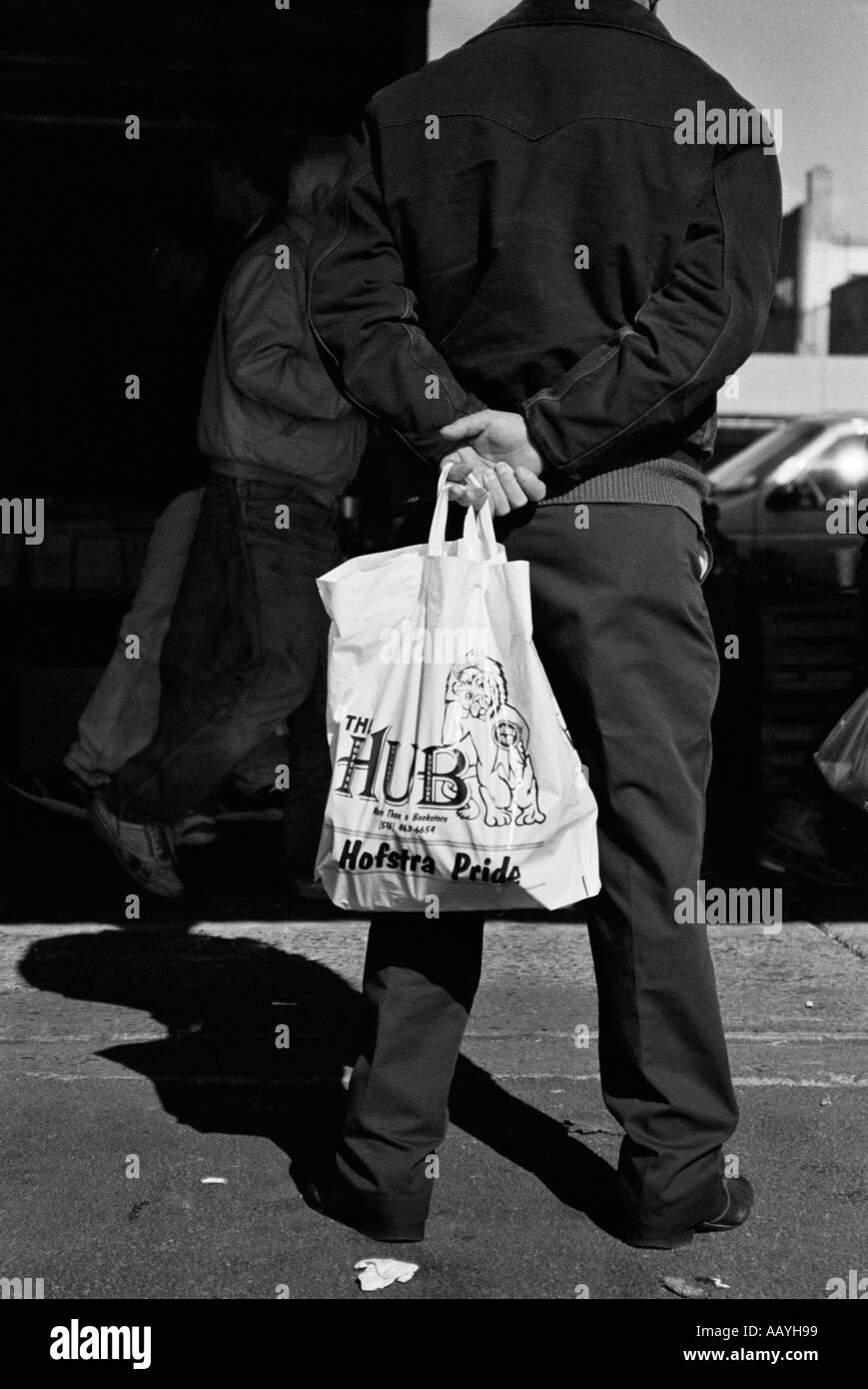 Homme tenant sac blanc portant des vêtements noirs Banque D'Images
