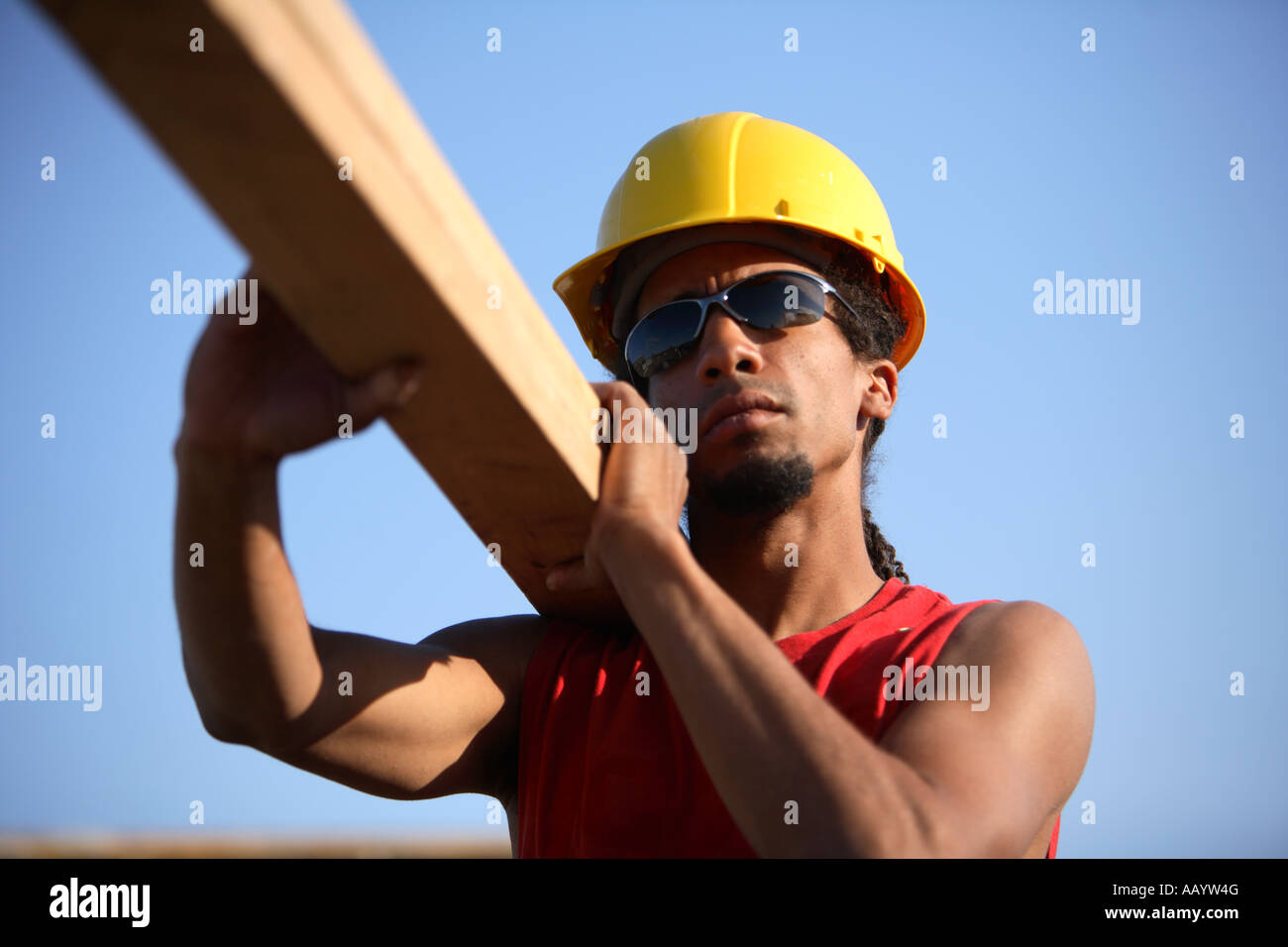 Construction Worker carrying des deux par quatre Banque D'Images