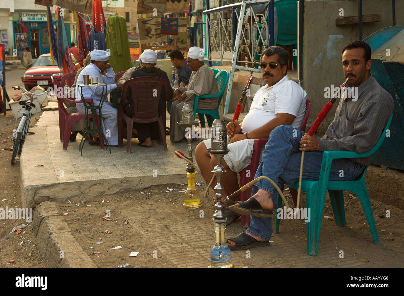 Deux hommes assis à l'extérieur de détente avec les autres tuyaux shisha tabac autour de la table en arrière-plan de la Mer Rouge Egypte El Quseir Al Qusayr Q Banque D'Images