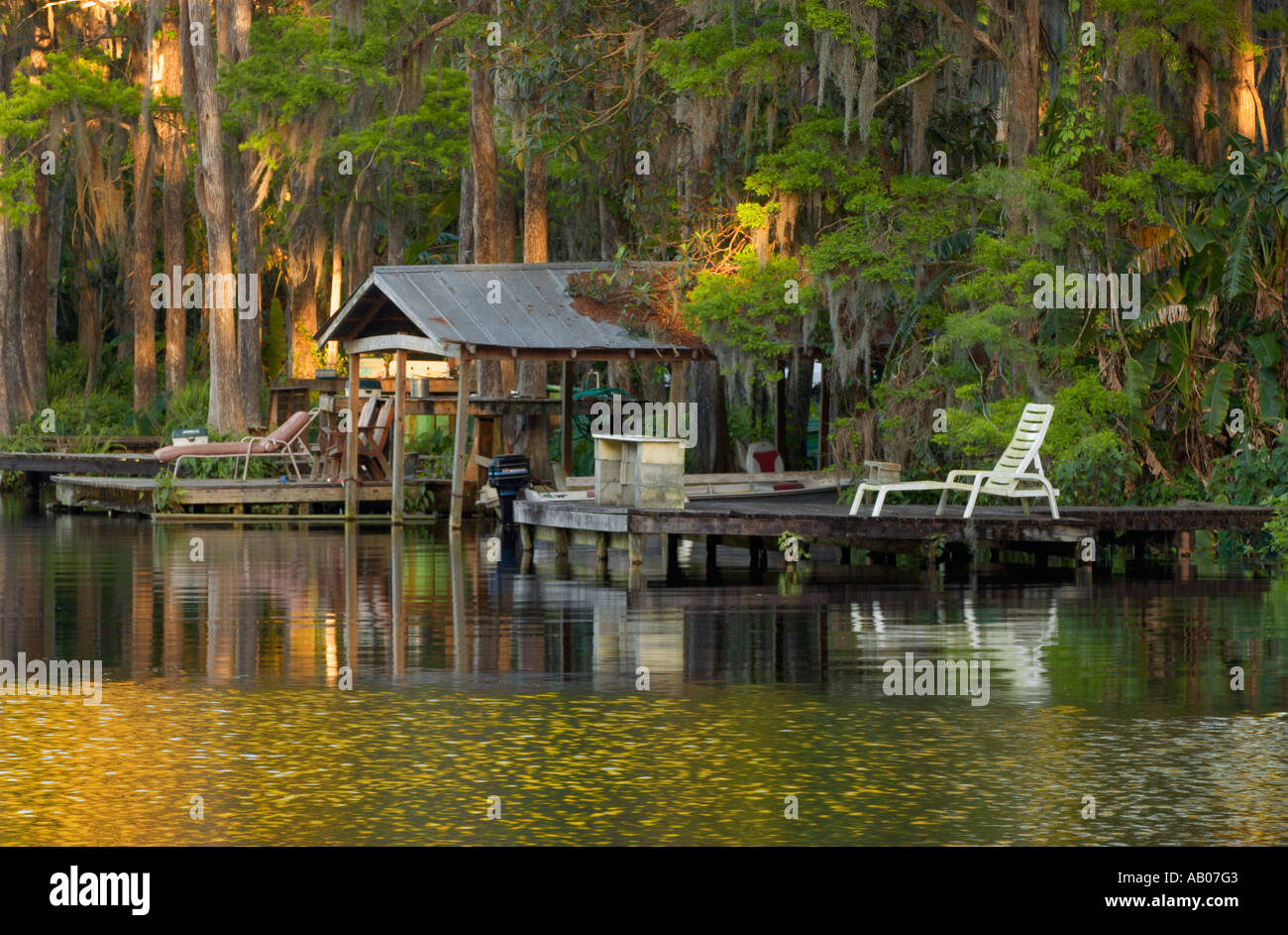 Une maison de bateau et un quai dans un coucher de soleil doré au lac Rousseau près de Dunnellon et Crystal River, Floride, États-Unis Banque D'Images Une maison de bateau et un quai dans un coucher de soleil doré au lac Rousseau près de Dunnellon et Crystal River, Floride, États-Unis Banque D'Images