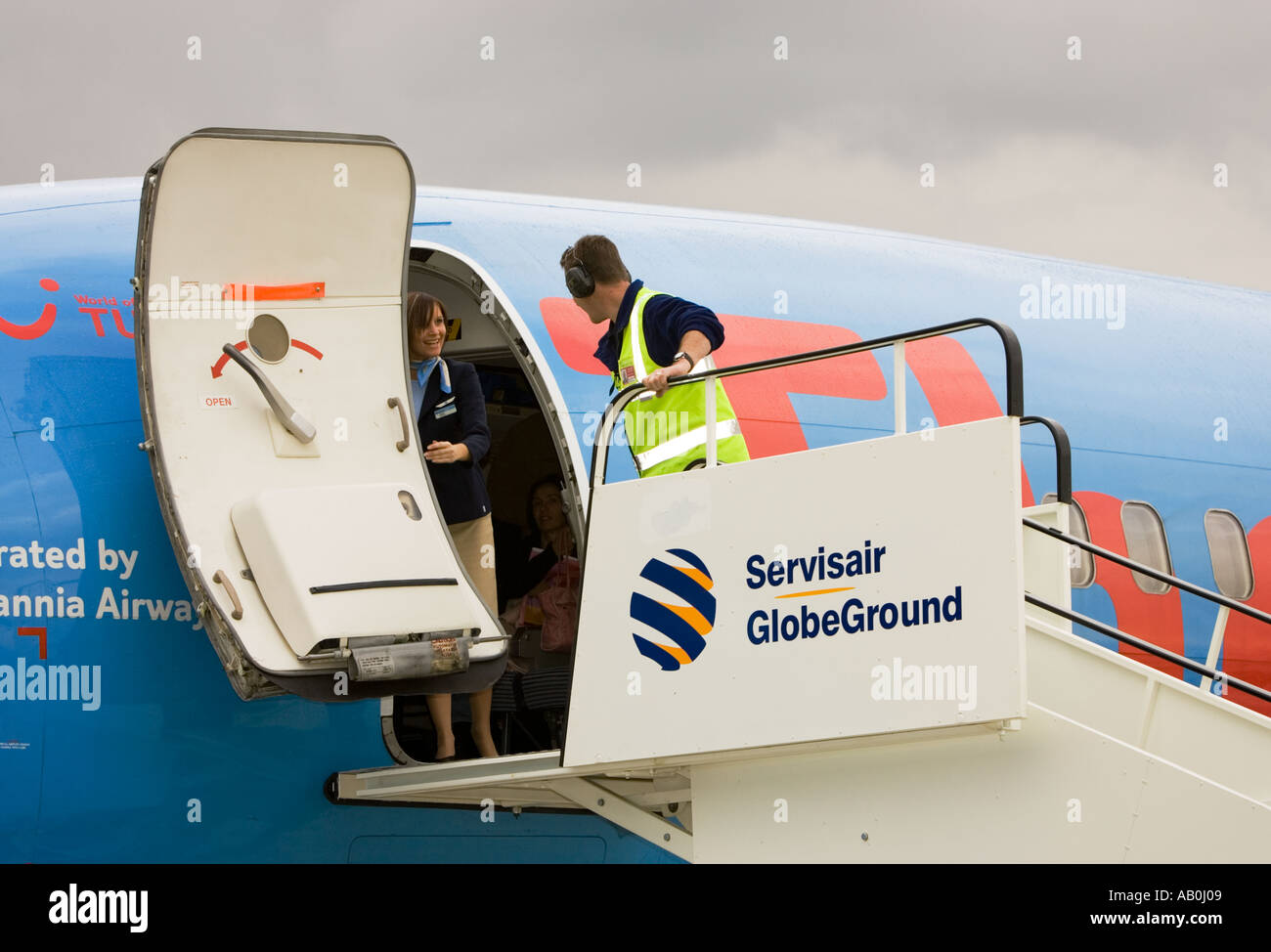 Le personnel du service de manutention au sol des mesures pour position porte de Boeing 737 qui vient d'arriver et parle à hôtesse, UK Banque D'Images