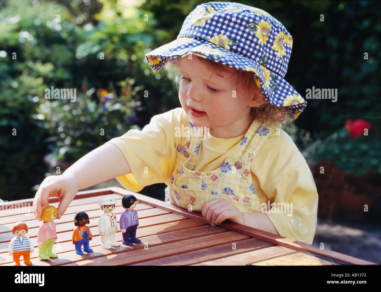 Petite fille au chapeau en jouant AVEC DES JOUETS DE JARDIN Banque D'Images