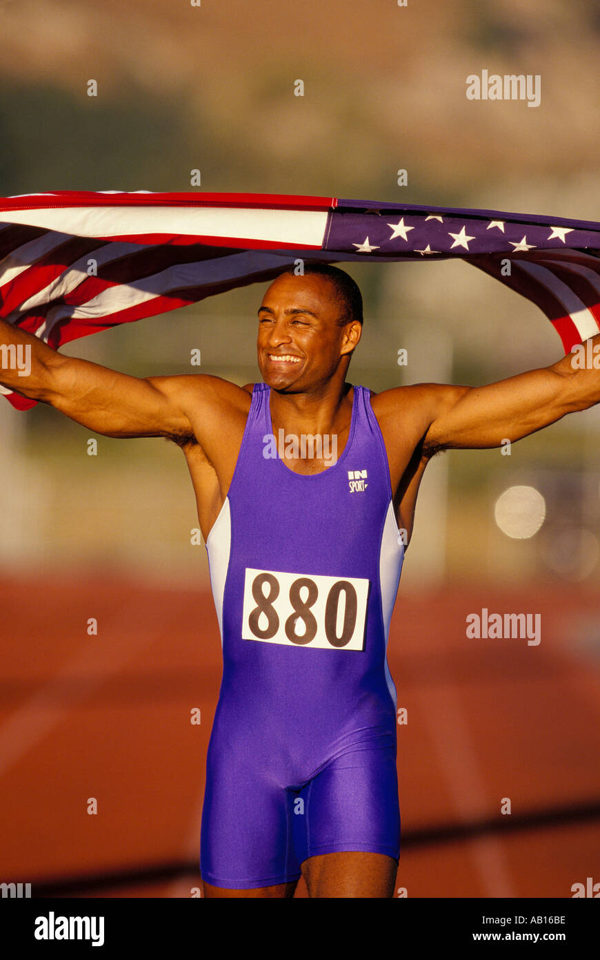 African American man running une victoire tour après un événement et tenant le drapeau américain sur les épaules Banque D'Images