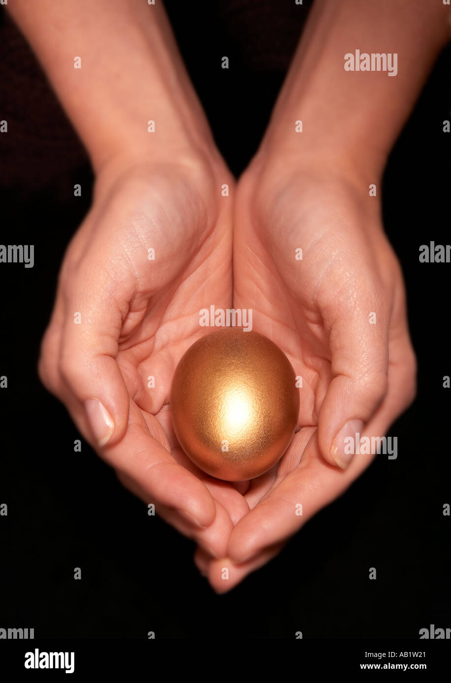 Jeune femme tenant DES OEUFS D'OR dans la paume des mains en coupe Banque D'Images