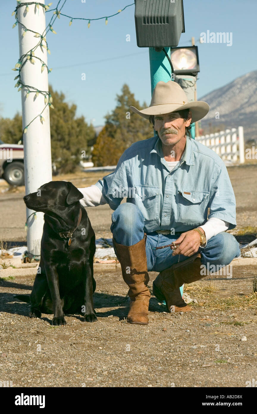 Cowboy avec son chien s'agenouiller au Sands Motel à l'intersection de la Route 54 380 à Carrizozo Nouveau Mexique Banque D'Images