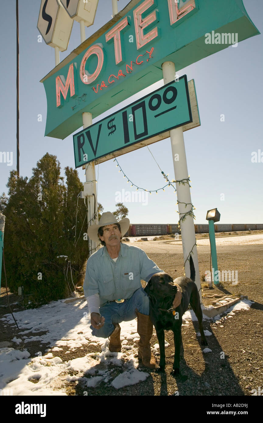 Cowboy et son chien à genoux en face du Sands Motel Sign avec RV Parking pour 10 situé à l'intersection de la Route 54 Banque D'Images