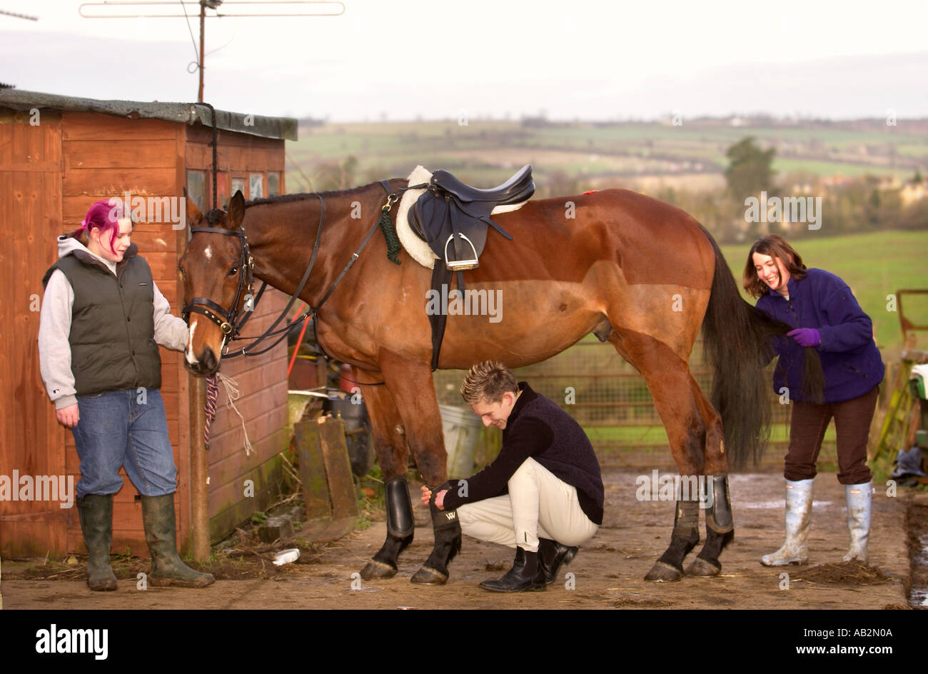 Un groupe de jeunes amoureux du cheval PRÉPARER UN CHEVAL POUR LA CHASSE À L'OXFORDSHIRE UK JAN 2005 Banque D'Images