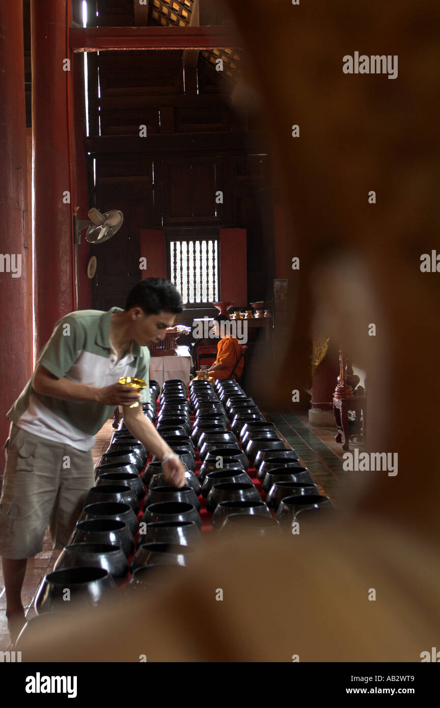 Offrant de l'argent dans un temple thaïlandais Banque D'Images
