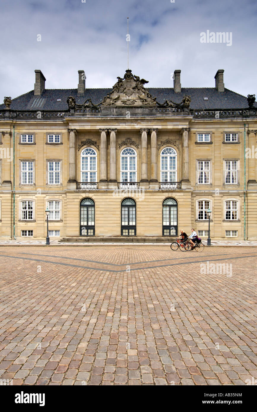 Deux femmes vélo passé Christian VIII, également connu sous le nom de Levetzau, du Palais d'Amalienborg à Copenhague en Danemark. Banque D'Images