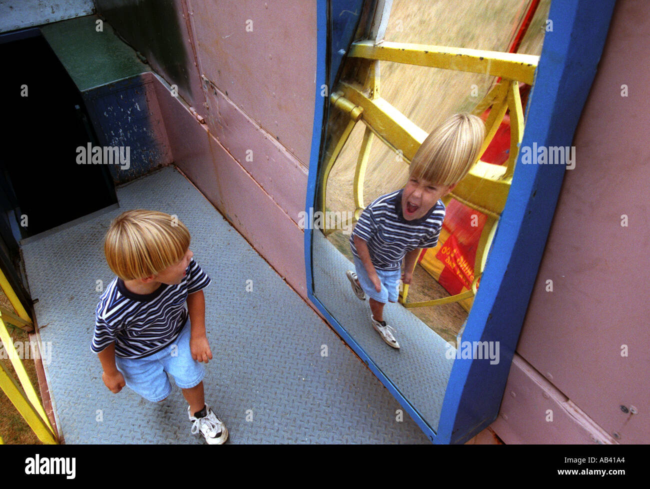 Boy walking passé funhouse mirror avec drôle de visage Photo Stock - Alamy