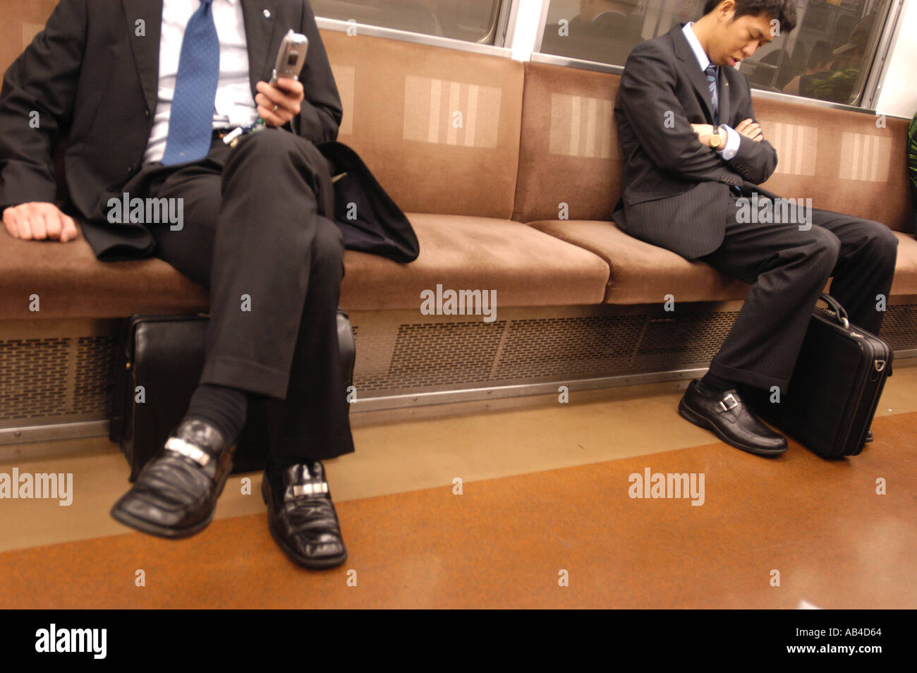 Les banlieusards, deux hommes assis sur un train de métro de Tokyo au Japon Banque D'Images
