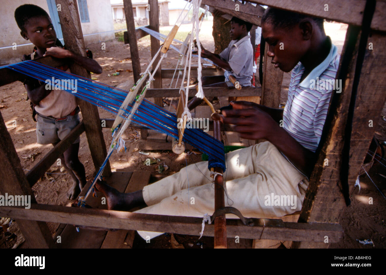Les jeunes hommes tissent Kente tissu dans un petit village en Afrique de l'Ouest Ghana Banque D'Images