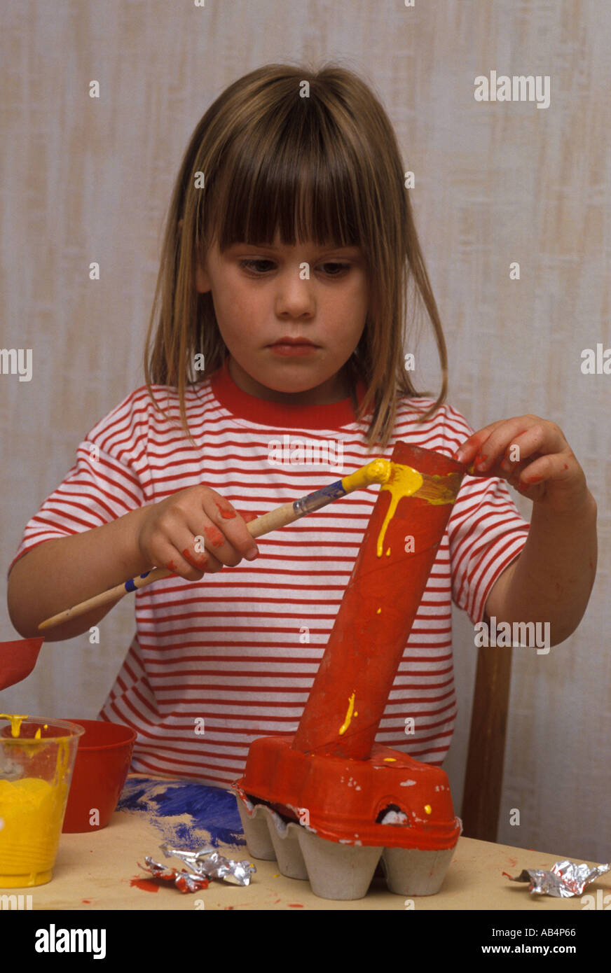 Enfant faisant construire avec des rouleaux de papier et les boîtes d'oeufs Banque D'Images