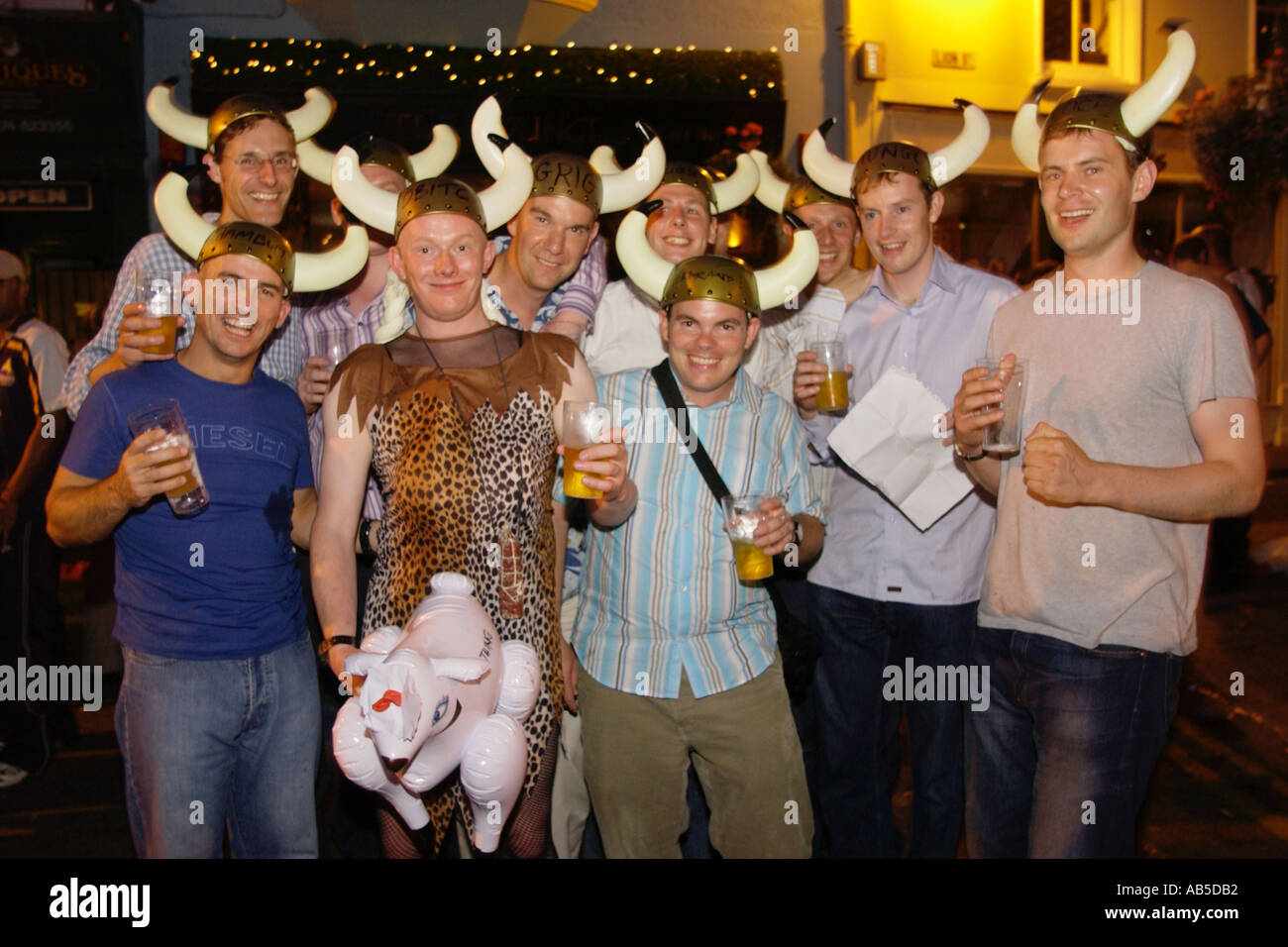 Groupe de jeunes hommes en chapeau de viking boire et passer un bon moment dans les rues de Brecon pour le festival de jazz annuel Banque D'Images