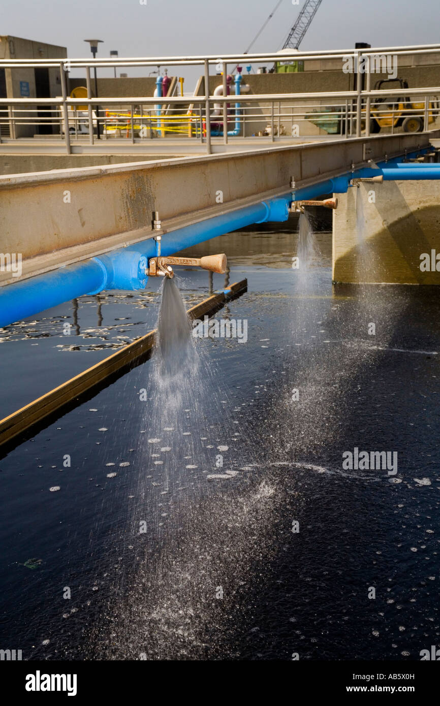 L'eau propre pulvérisateurs par l'exposition à la lumière ultraviolette du soleil dans les bassins de décantation. Banque D'Images