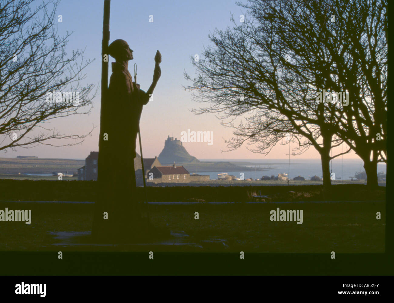 Statue de Saint Aidan avec Château de Lindisfarne au-delà, l'Île Sainte, Northumberland, England, UK. Banque D'Images