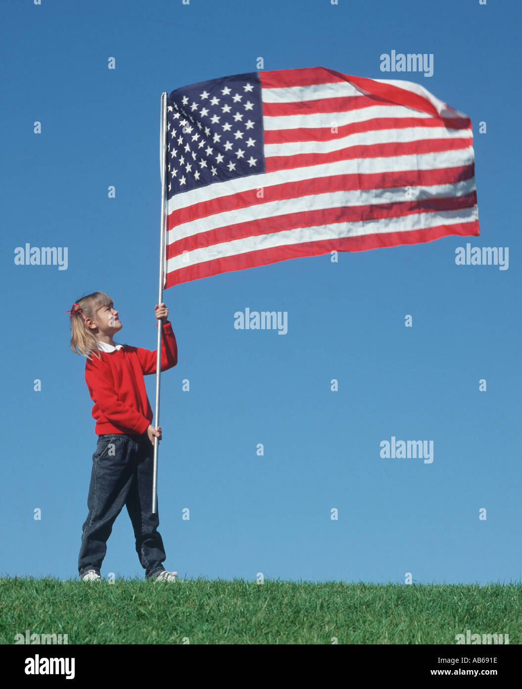 Petite fille sur hill holding American flag sur perche Banque D'Images