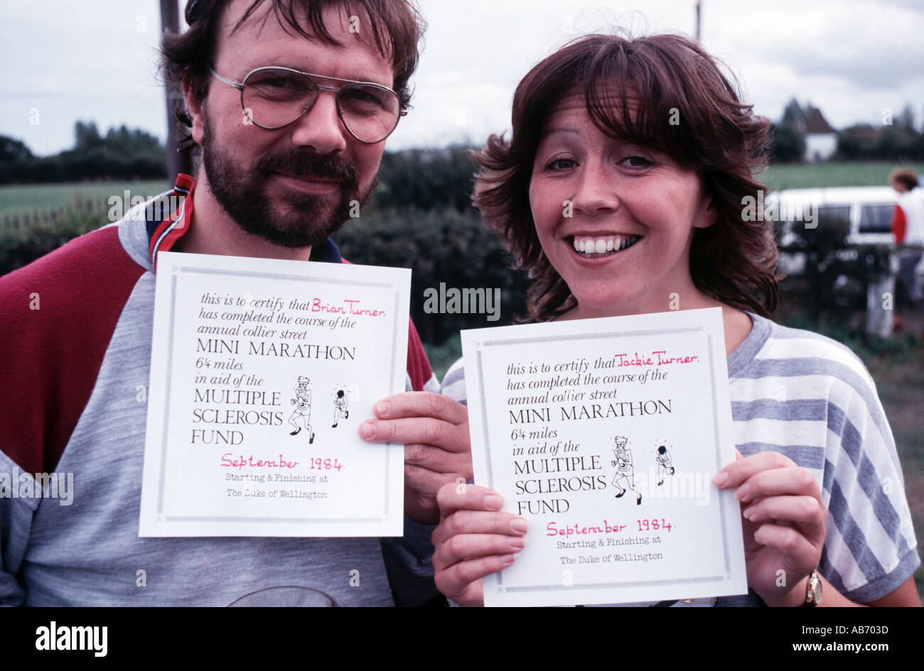 Un homme et une femme, tous deux nés en 1950 photographié en 1984 montrant des certificats pour terminer un 625 km course de bienfaisance Banque D'Images
