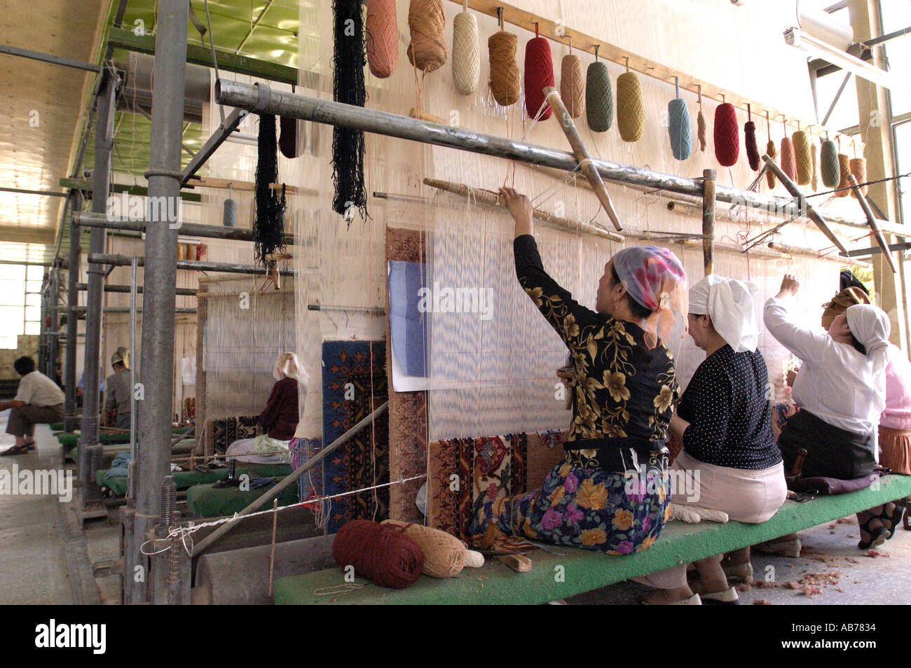 Les travailleurs Ouïghours musulmans femelle dans une fabrique de tapis traditionnels en Chine Xinjiang Hotan Banque D'Images