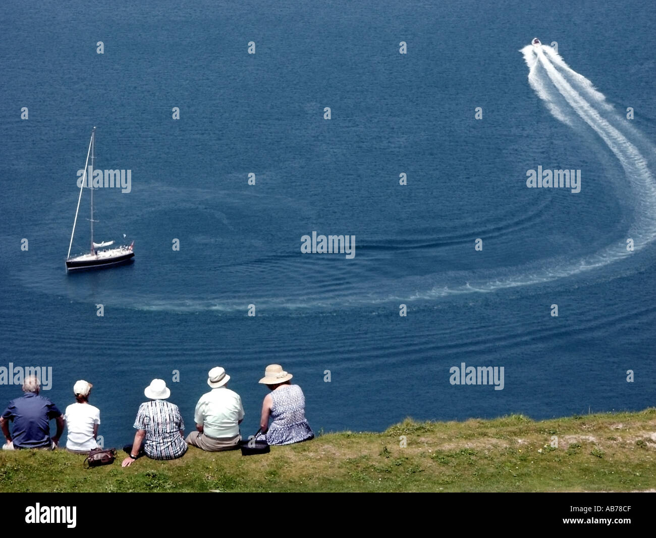 Île de Wight vue arrière les gens portant des chapeaux de soleil assis autour de Killing Time sur la falaise surplombant la mer bleue jour ensoleillé style de vie Angleterre Royaume-Uni Banque D'Images