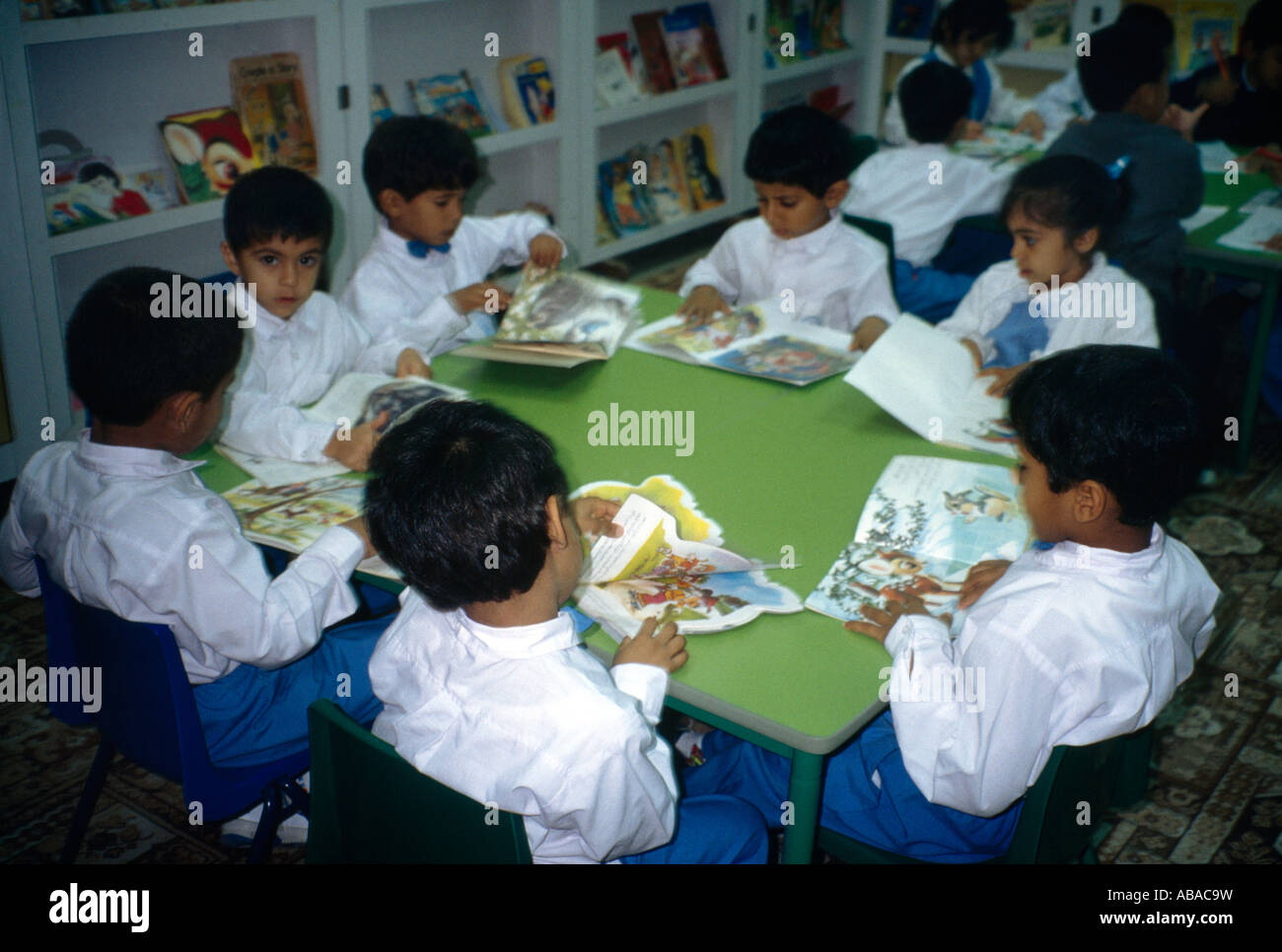 Abu Dhabi ÉMIRATS ARABES UNIS Les enfants de l'école primaire Histoire lecture Livres en classe Banque D'Images