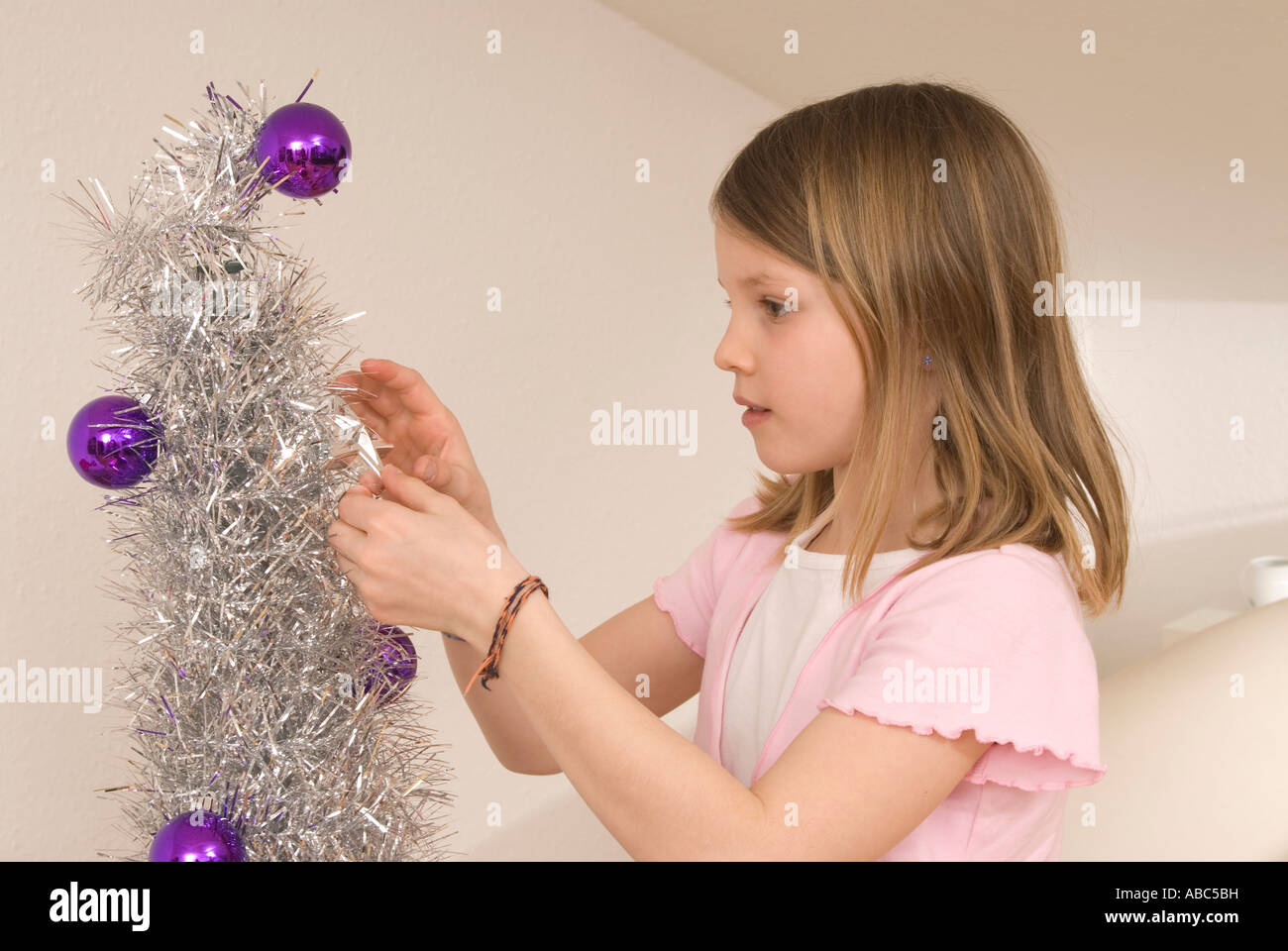 Girl decorating Christmas Tree Banque D'Images