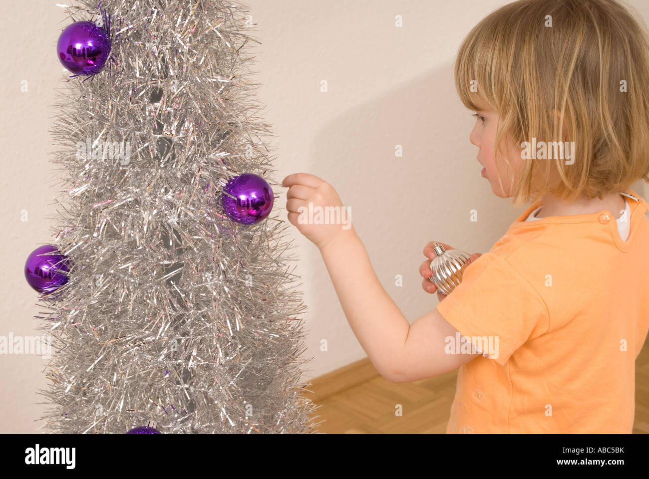 Little girl decorating Christmas Tree Banque D'Images