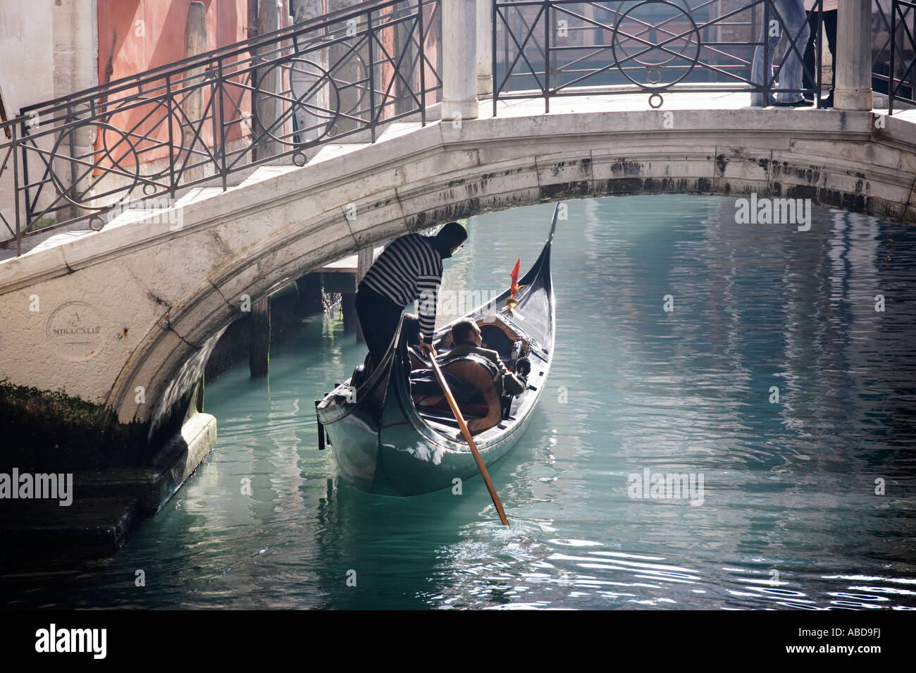 Un gondolier passe sous un pont à Venise Italie Banque D'Images