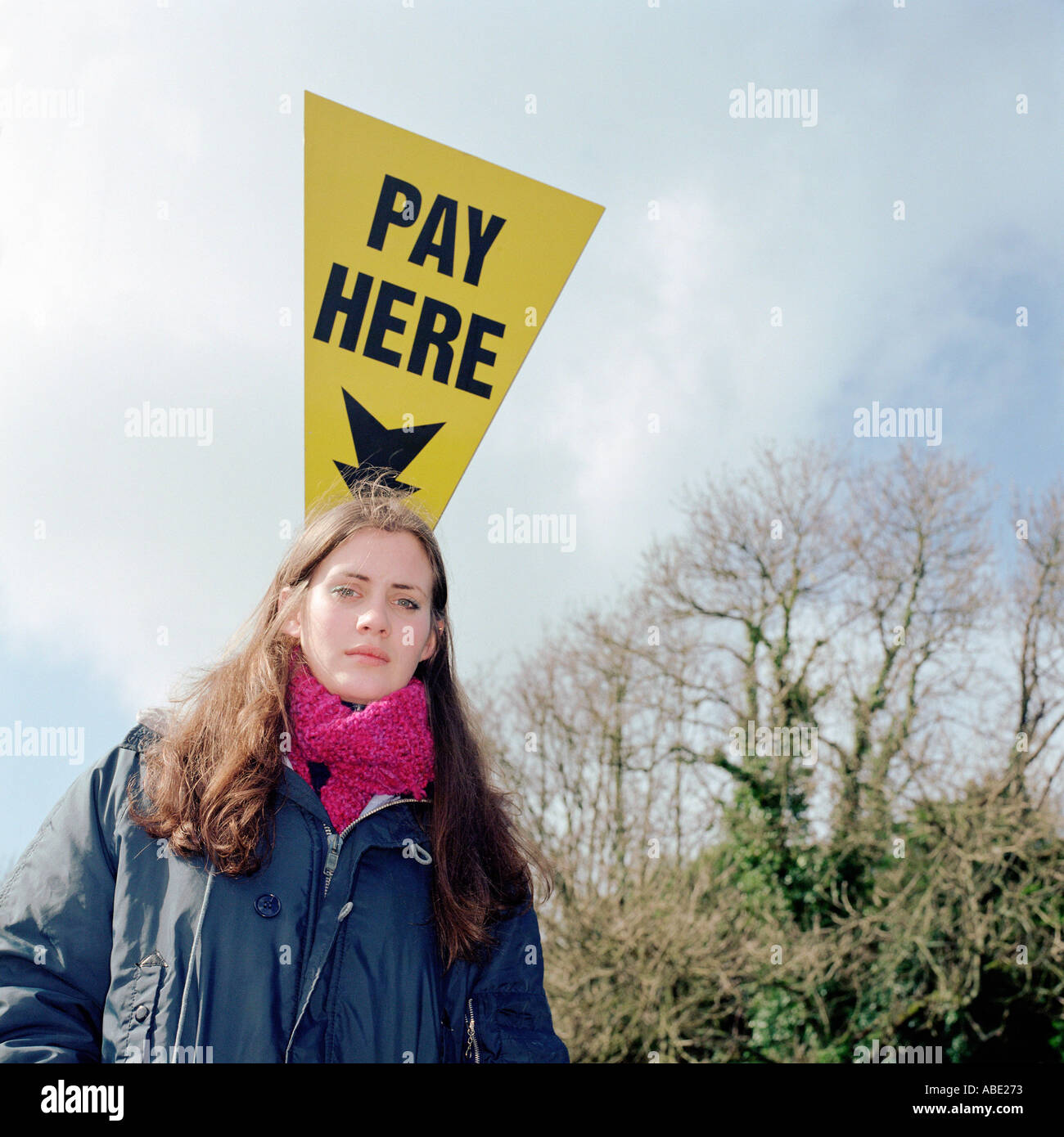 Girl standing by payer ici s'inscrire Banque D'Images