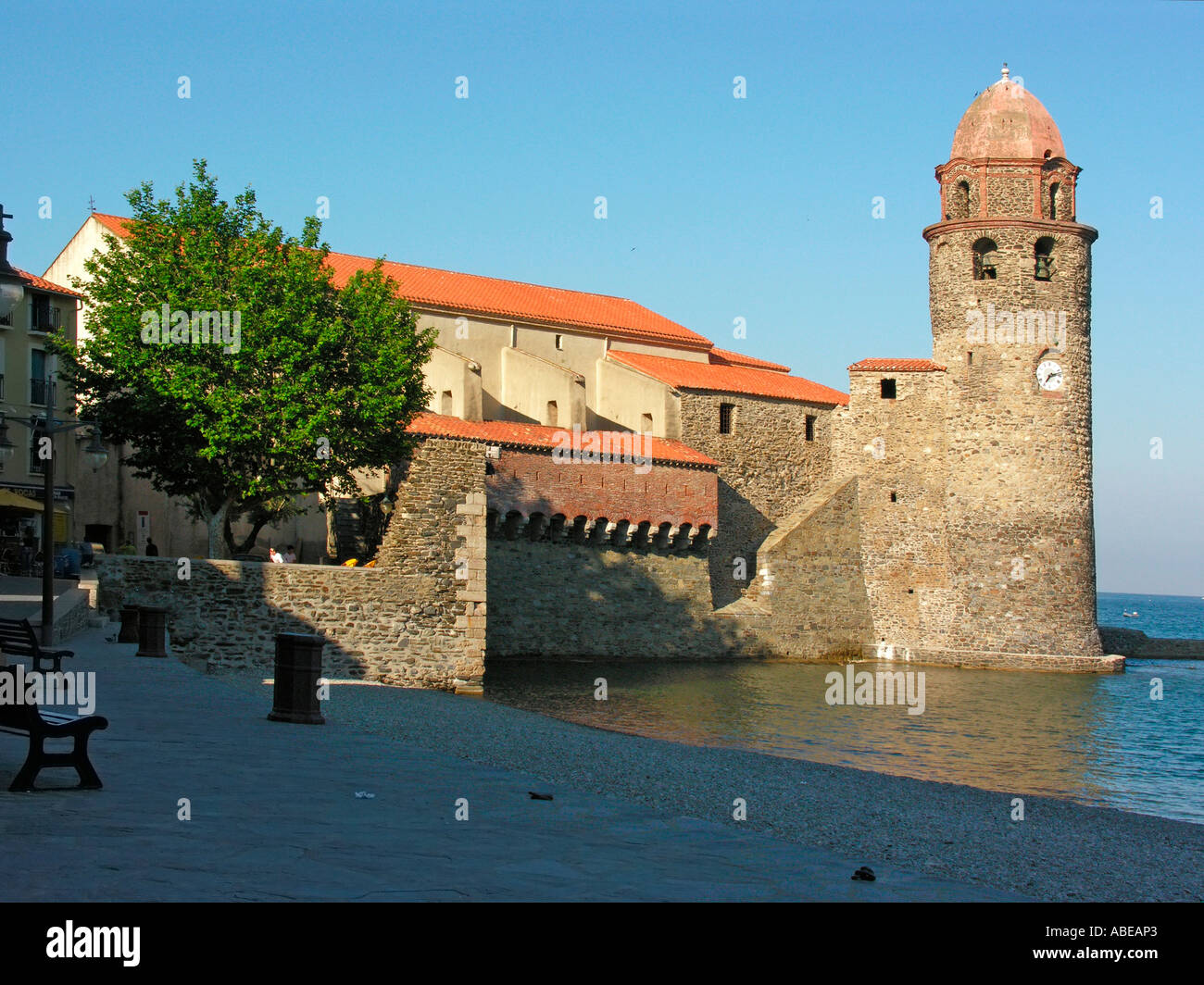 Plage vide dans la baie de Collioure et l'église fortifiée Notre-Dame des Anges avec beffroi belltower utilisé également comme phare Banque D'Images