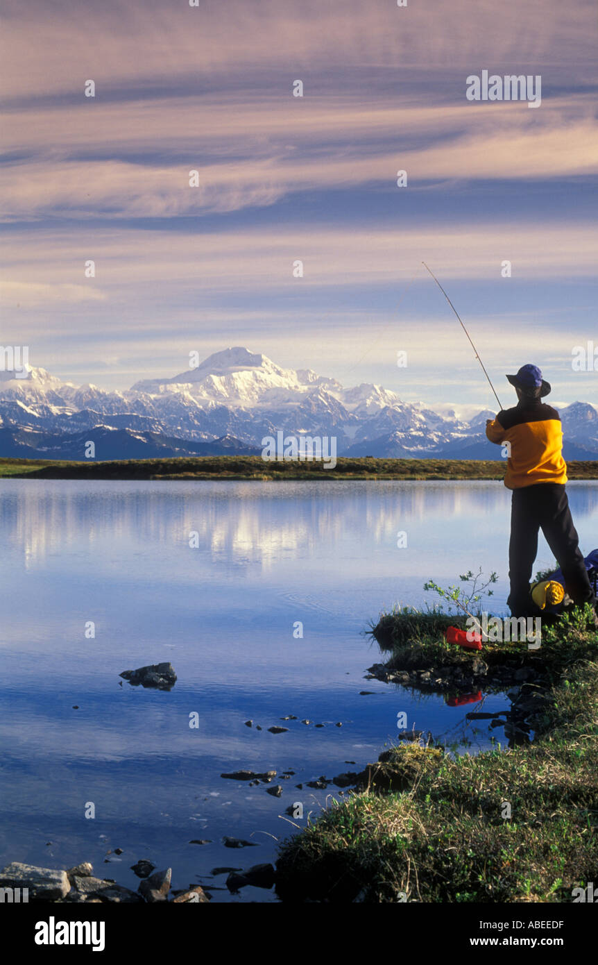 Backpacker s'arrête de pêcher au lac avec le Mont McKinley en arrière-plan / Peters Glacier, Denali National Park, Alaska Banque D'Images