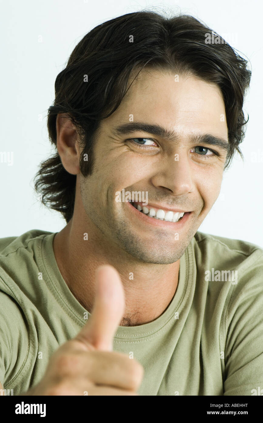 Man smiling at camera, giving Thumbs up signal, tête et épaules, portrait Banque D'Images