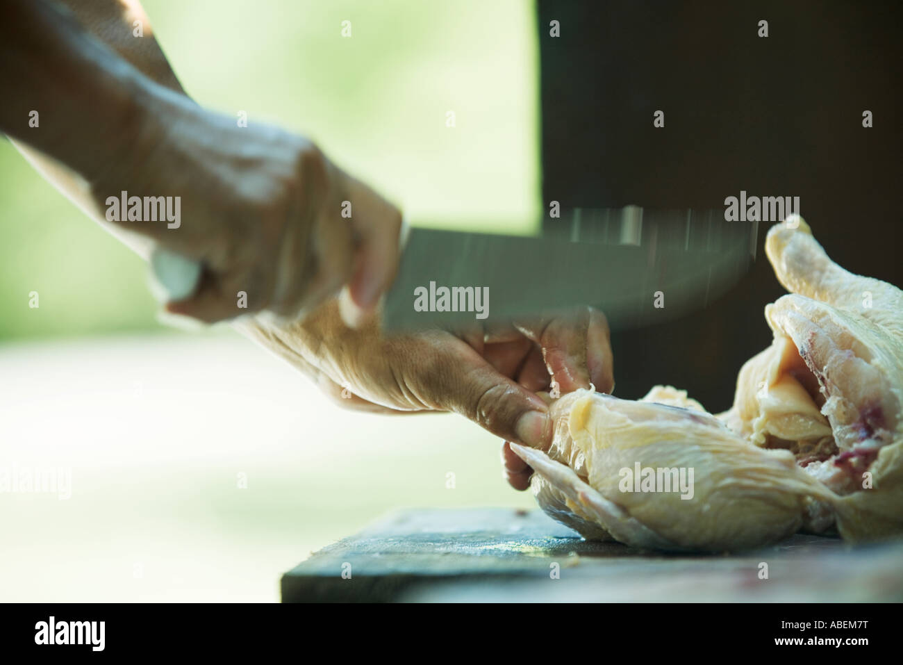 L'homme de couper le poulet, blurred motion, close-up Banque D'Images