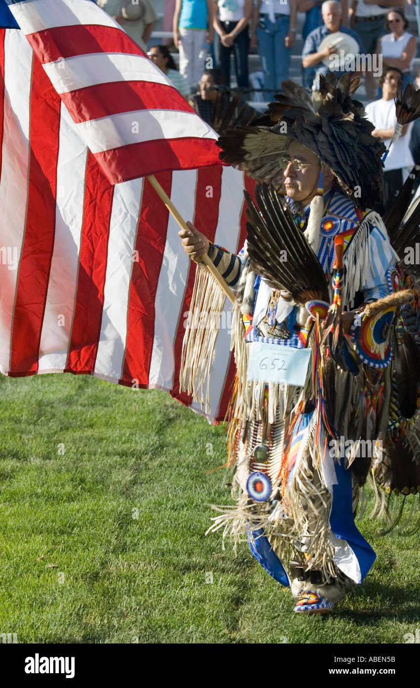 Un Amérindien en full regalia lors d'un pow-wow dans le nord de l'Utah portant le drapeau des États-Unis au cours de la cérémonie d'ouverture Banque D'Images