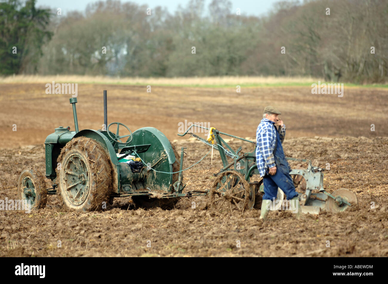 Tracteur vintage et de l'homme dans un champ, l'Angleterre, Royaume-Uni Banque D'Images