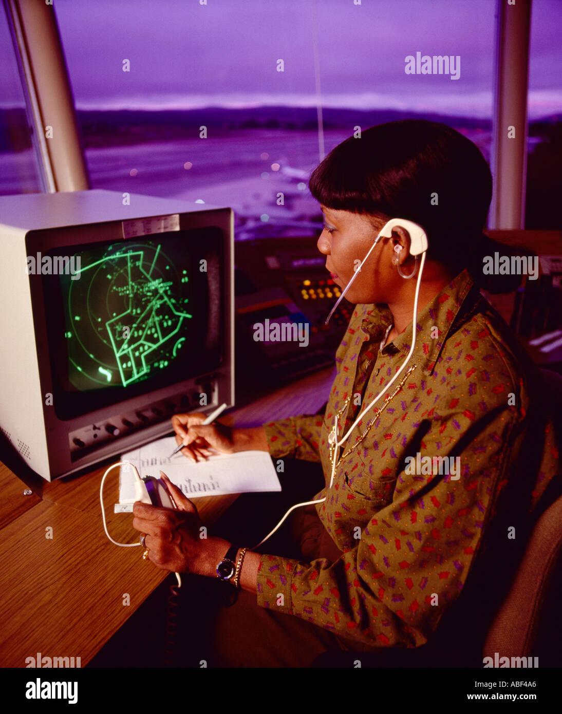 - Contrôle de la circulation aérienne contrôleur aérien d'une femme travaillant dans une tour de contrôle du trafic aérien dans un aéroport au crépuscule / USA. Banque D'Images