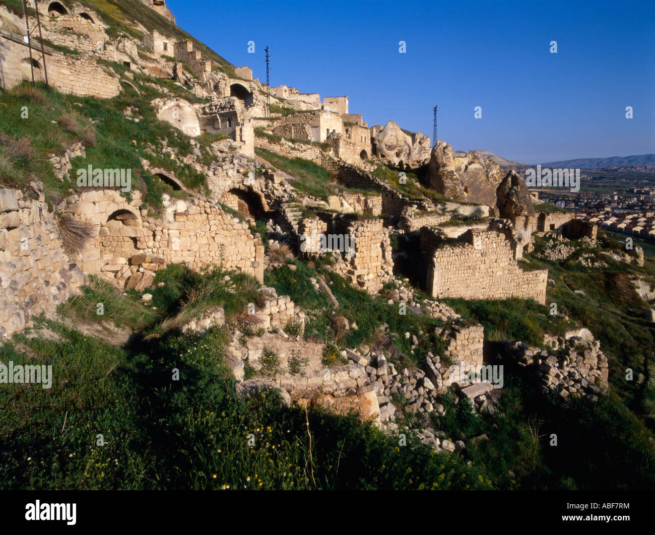 La lumière du soleil tôt le matin jette une lueur chaude pendant les premières habitations troglodytiques dans le village d'Urgup, Anatolie centrale, Turquie Banque D'Images