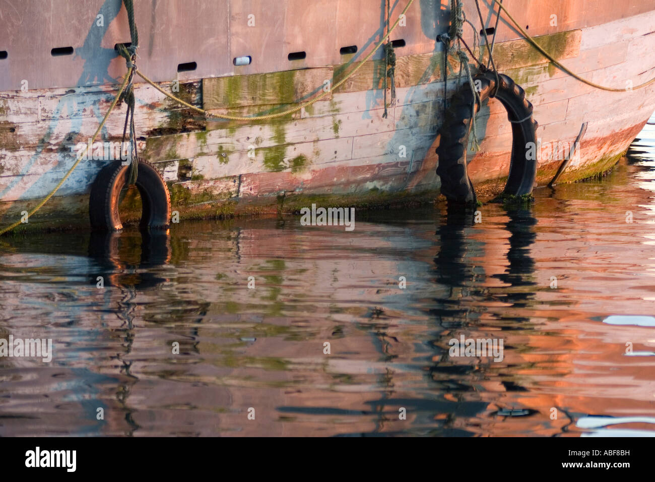 Deux pneus se suspendre à un vieux bateau rouillé, dans le port de Newport, Rhode Island. Banque D'Images