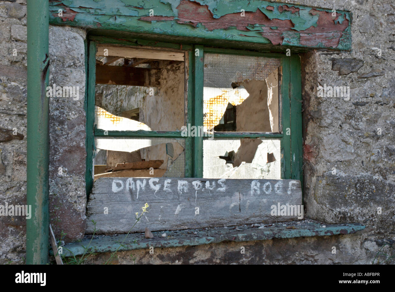 Bâtiment abandonné et fenêtre cassée avec panneau d'avertissement Banque D'Images