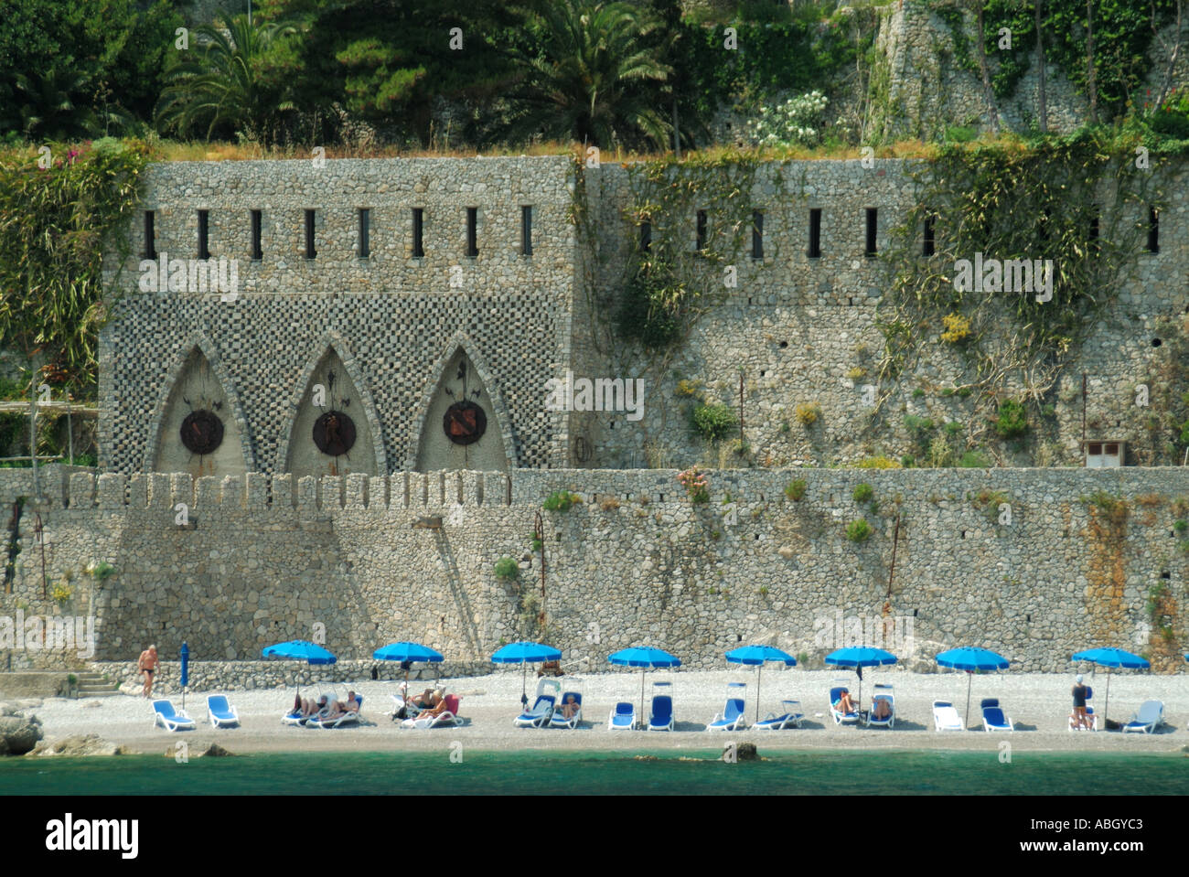 Plage privée en face des fortifications historiques partie UNESCO Amalfi ascenseurs de la côte relient aux bâtiments de l'hôtel au-dessus, ville Amalfi Campanie Italie Banque D'Images