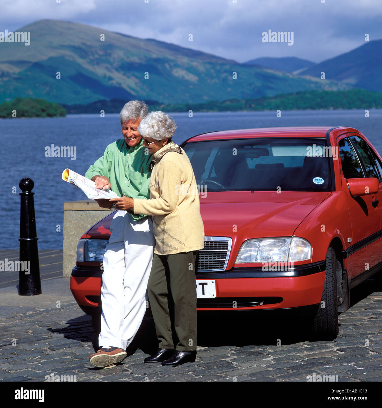 MATURE COUPLE READING MAP EN VOITURE AVEC LE LOCH LOMOND ECOSSE Banque D'Images